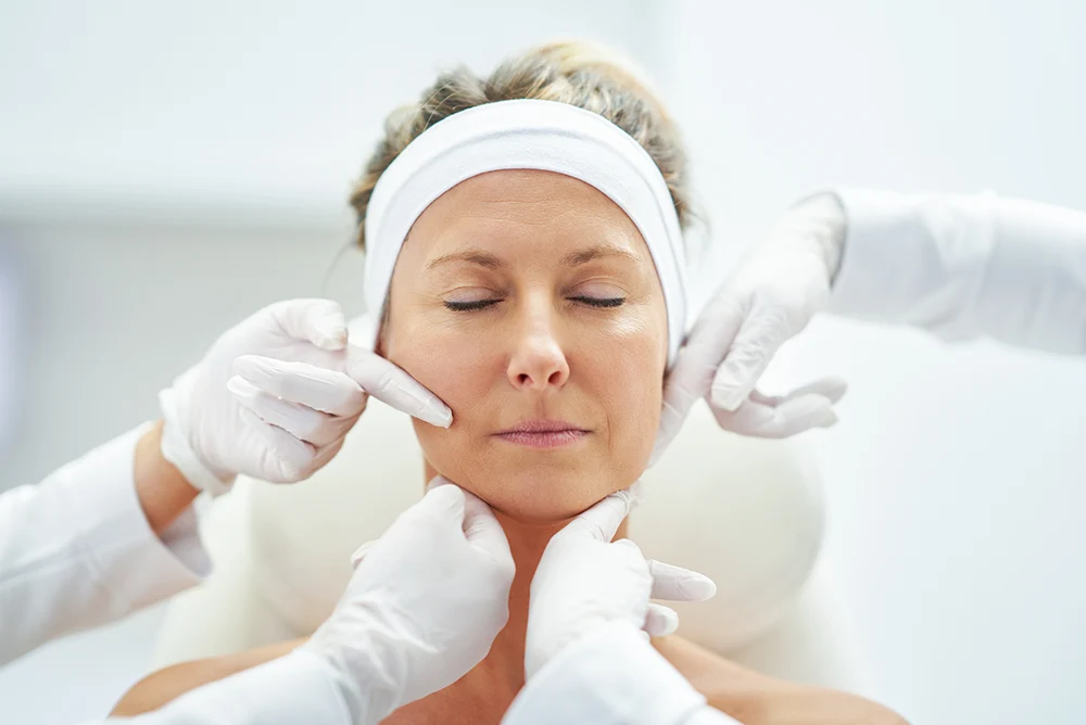 Patient receiving facial assessment and skin evaluation during cosmetic consultation for deep plane facelift treatment in New York
